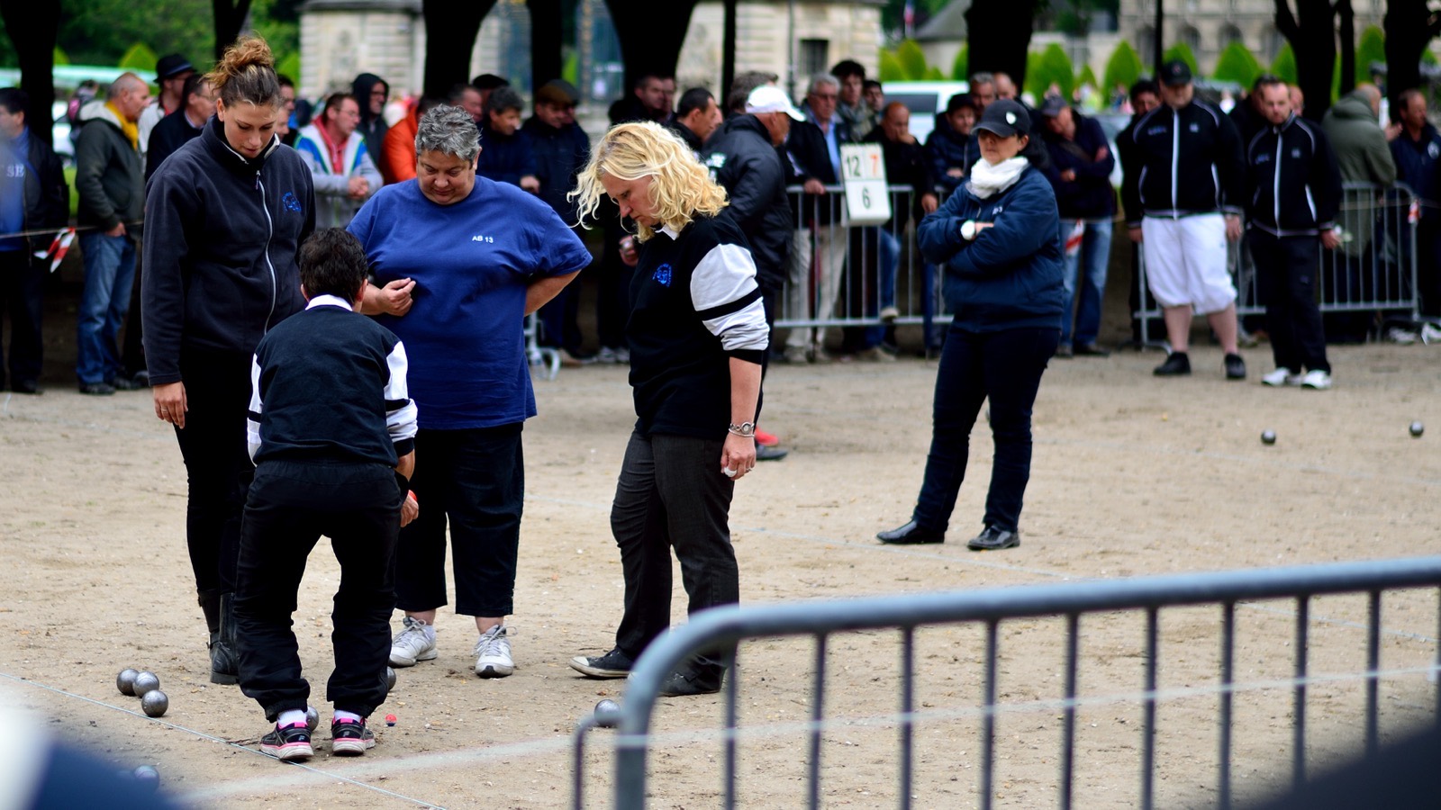 Enfants et adultes réunis autour d'une partie de pétanque